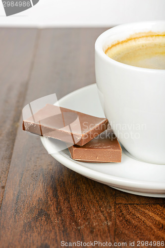 Image of Half cup of coffee with chocolate on table
