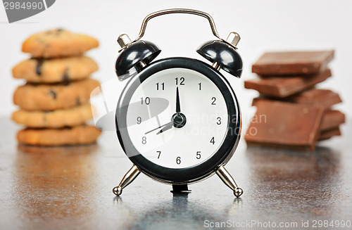 Image of Black alarm clock with sweets