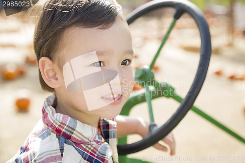 Image of Mixed Race Young Boy Playing on Tractor