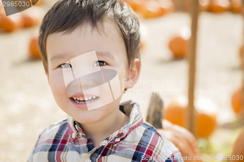 Image of Mixed Race Young Boy Having Fun at the Pumpkin Patch