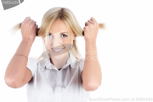 Image of Pretty smiling girl with hands in hair