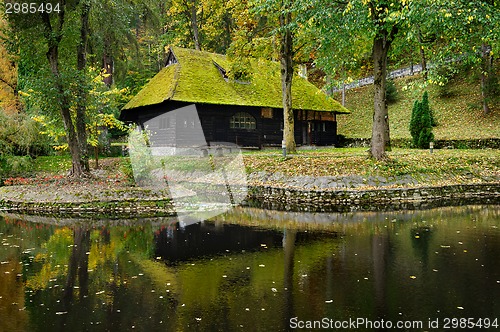 Image of wooden house with moss on roof