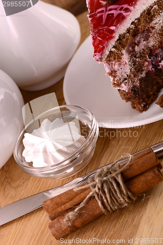 Image of Piece of chocolate cake and white meringue on wooden background