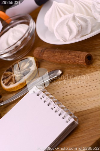 Image of meringue, lemon and cinnamon on wooden backgroubd