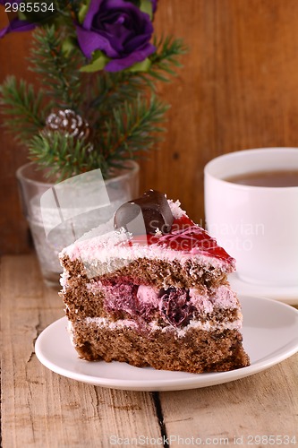 Image of pieces of cake on wooden background with flowers and tea cup