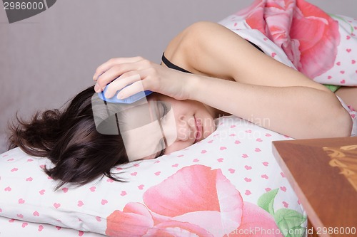 Image of The girl fell asleep with alarm at the ear