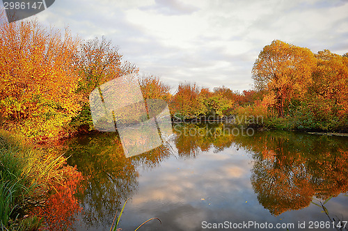 Image of Landscape with colorful autumn trees reflected in the river