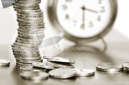 Image of A stack of coins and alarm clock