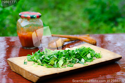 Image of Still life of sliced green onions on a cutting Board, wooden spo