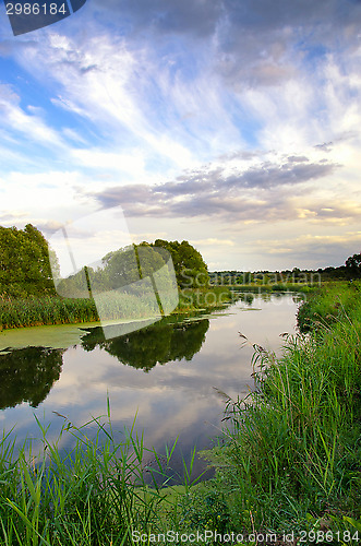 Image of Summer landscape with the sky and clouds reflecting in the river