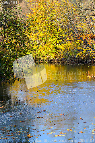 Image of Autumn landscape with reflection in the water of trees with brig