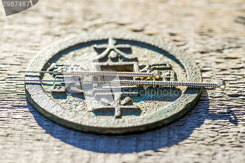 Image of acupuncture needles on chinese coin