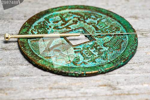 Image of acupuncture needle on chinese coin