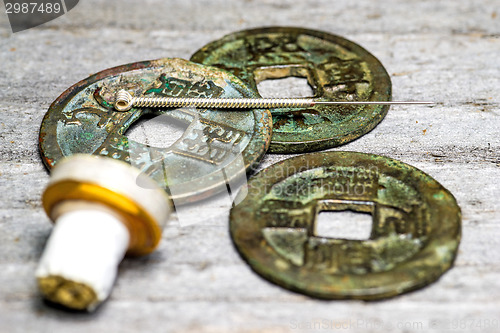 Image of acupuncture needle on chinese coins