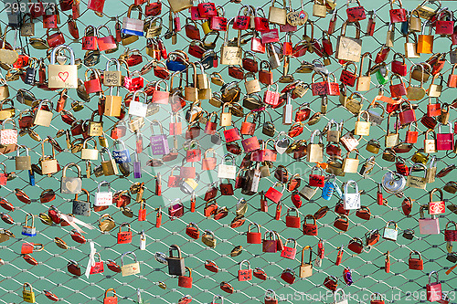 Image of Plenty of colorful locks on bridge sign of eternal love devotion