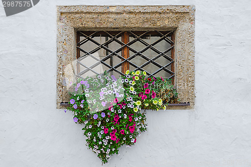 Image of Colorful flowers on window exterior of old european house