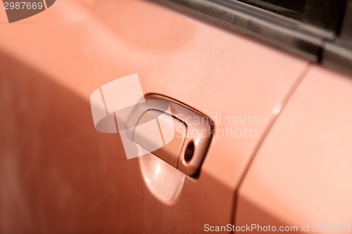 Image of Handle of an orange car closeup