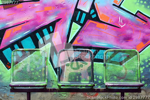 Image of Street chairs in front of graffiti wall