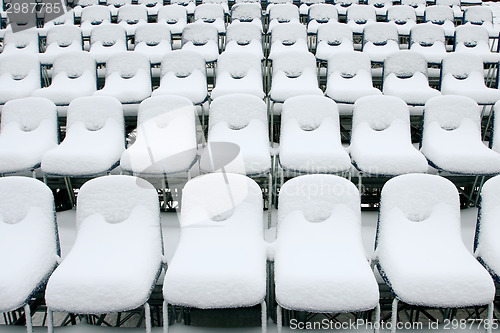 Image of White stadium chairs covered in snow