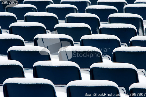 Image of Blue plastic chairs covered in snow