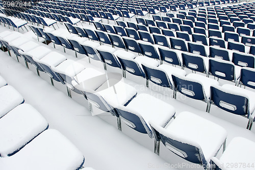 Image of Empty plastic chairs covered in snow