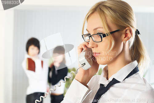 Image of Calling attractive woman at colleagues background