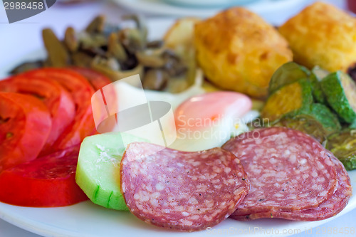 Image of Sausage and scrambled eggs with owoseni on the plate.