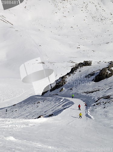 Image of Snowboarders and skiers on ski slope at sun day