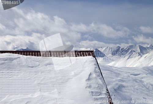 Image of Snowy roof and cloudy mountains