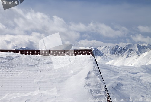 Image of Snowy roof and cloudy mountains