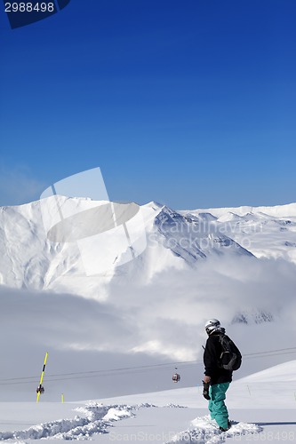 Image of Snowboarder on off-piste slope with new fallen snow at nice day
