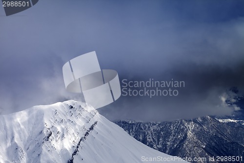 Image of Sunlight top of mountains and storm clouds