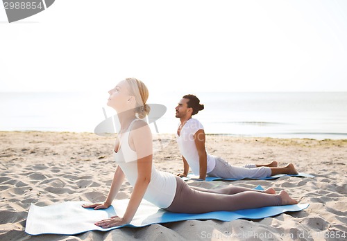 Image of couple making yoga exercises outdoors