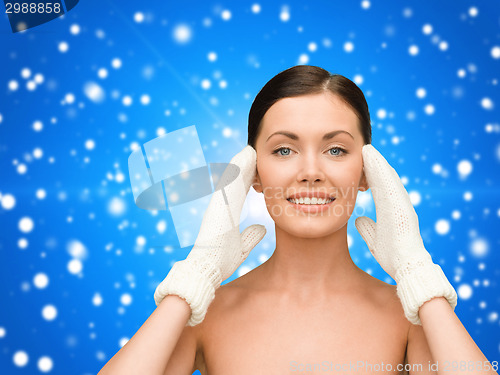 Image of smiling young woman in white mittens