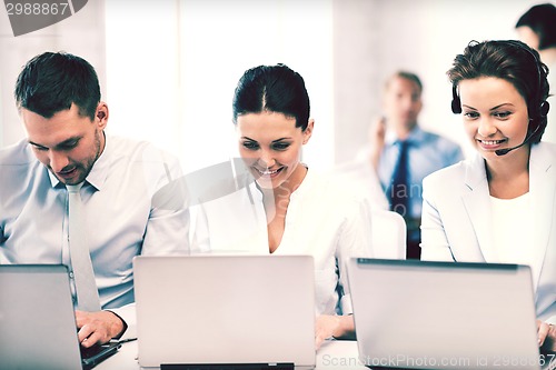 Image of group of people working with laptops in office