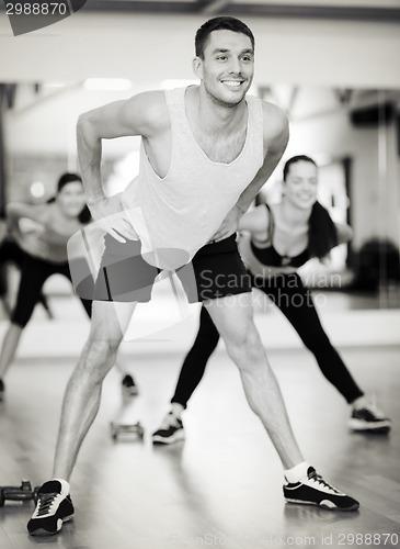 Image of smiling male trainer working out in the gym