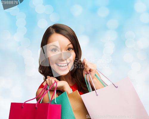 Image of smiling woman with colorful shopping bags