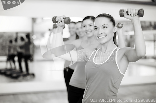 Image of group of smiling people working out with dumbbells