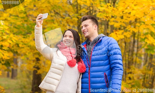 Image of smiling couple hugging in autumn park