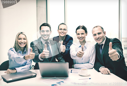 Image of business team showing thumbs up in office