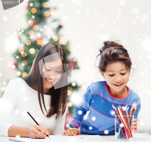 Image of mother and daughter with coloring pencils indoors