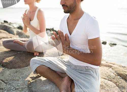 Image of close up of couple making yoga exercises outdoors