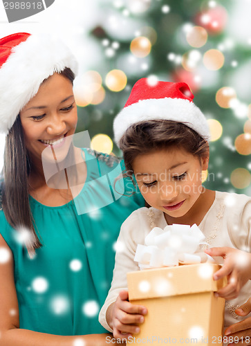 Image of happy mother and child girl with gift box