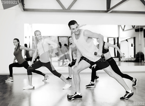 Image of group of smiling people working out with dumbbells