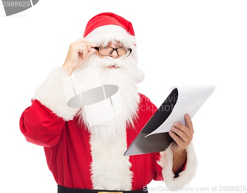 Image of man in costume of santa claus with notepad