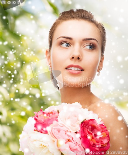 Image of woman with diamond earrings, ring and flower