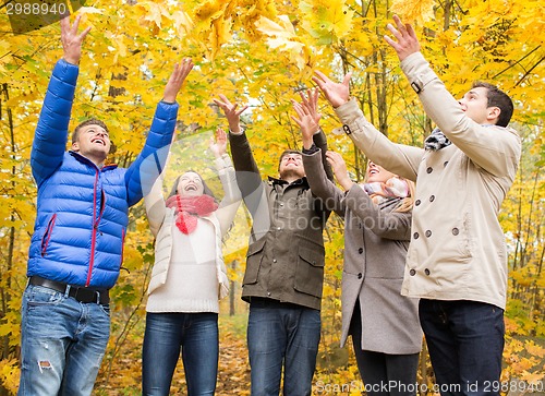 Image of group of smiling men and women in autumn park