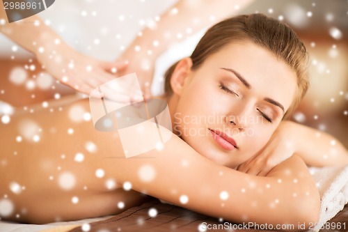 Image of beautiful young woman in spa salon getting massage