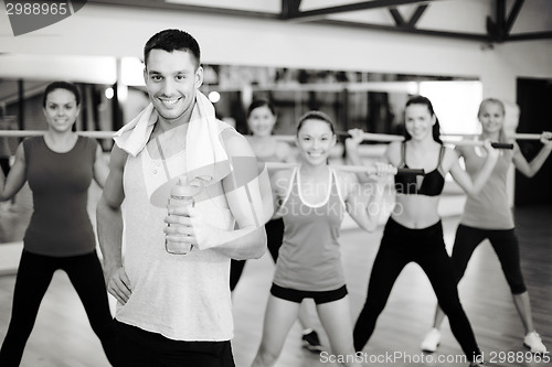 Image of smiling trainer in front of group of people