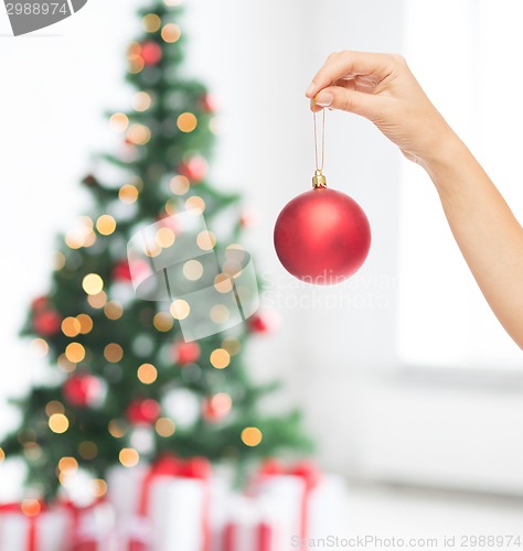 Image of close up of woman in sweater with christmas ball